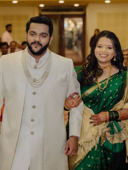 The couple's entry at their engagement. The bride's makeup is elegant and traditional, perfectly matching her green saree and the celebratory atmosphere.