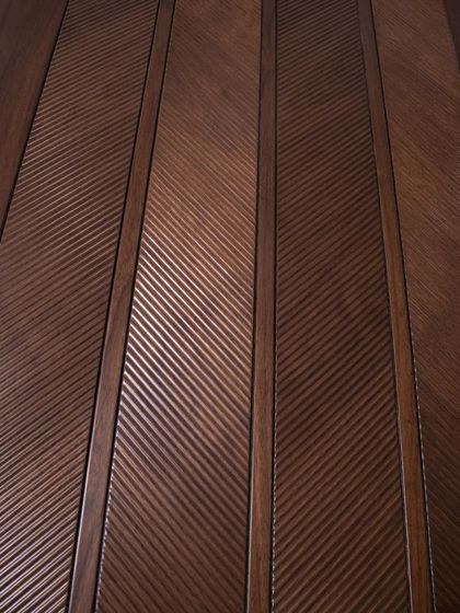 A close-up of the ripped flute chevron design on an American walnut veneer door, showing the intricate texture and pattern.