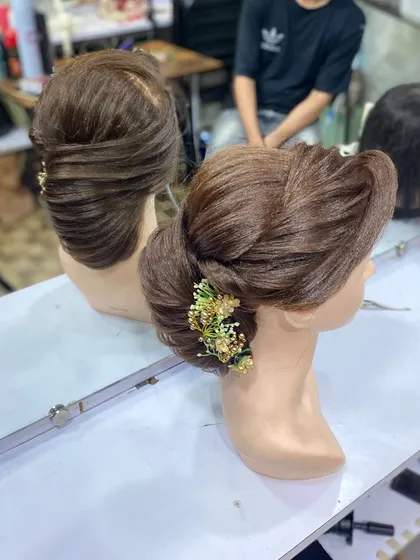 Another view of the student's elegant side bun. They learn to create smooth, polished looks that are perfect for formal occasions.