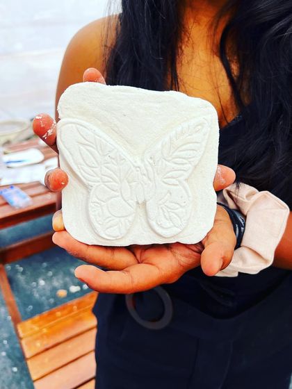 A participant holding a butterfly she carved from a lightweight block during our carving workshop at Rider Mania in Goa.