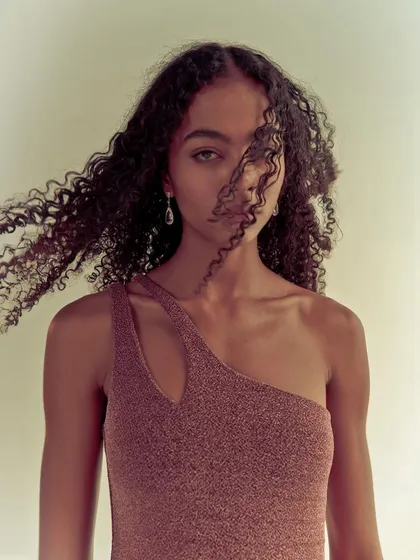 A portrait for Melova with wind-blown hair. The movement adds a soft, dynamic element to the shot, partially obscuring the model's face for an artistic effect.