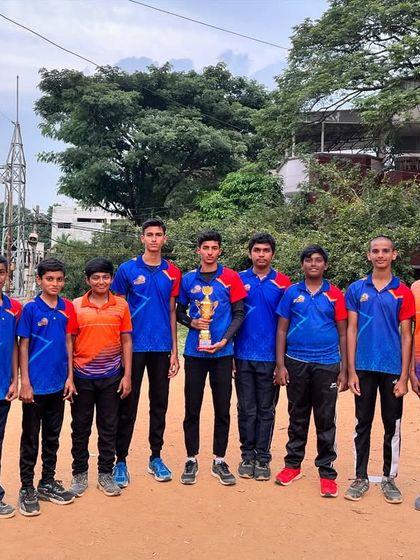 The sub-junior boys' team posing with their hard-earned trophy at the district-level netball tournament.