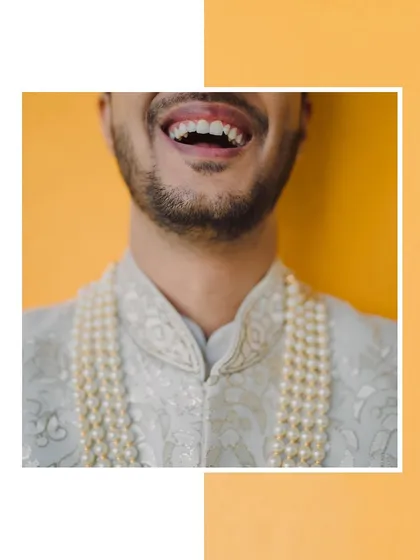 A creative close-up focusing on the groom's joyful laugh, a candid shot that captures his personality.