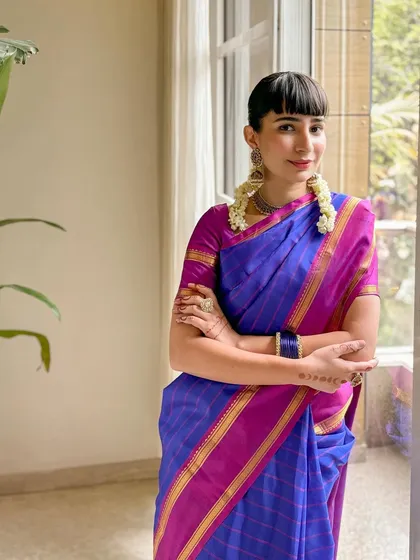 A classic look in a beautiful blue and magenta Kanjeevaram saree, paired with traditional temple jewellery.