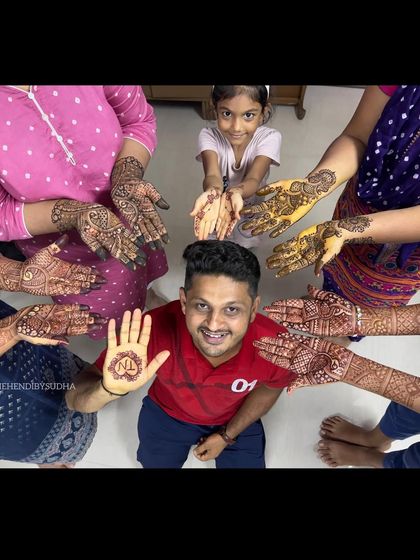 Mehendi is for the whole family. Here's a fun shot with the groom showing his simple initial mehendi, surrounded by the beautifully decorated hands of his family members.