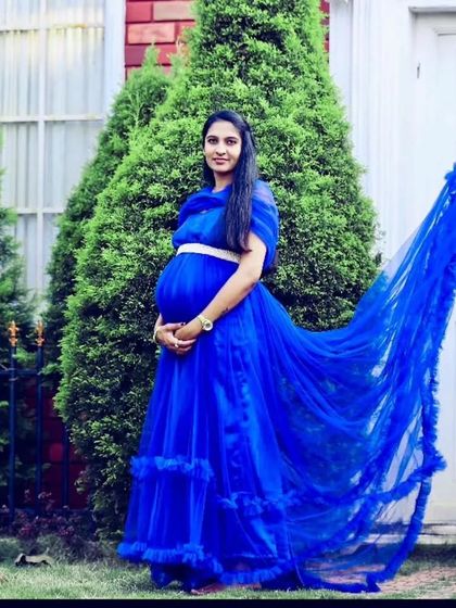 The long, ruffled trail of this royal blue maternity gown looks incredible in outdoor settings. It's a versatile dress that works for many different photoshoot concepts.