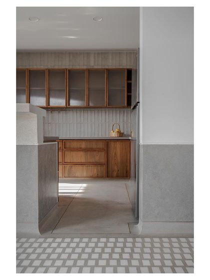 Sunlight streaming into the kitchen, catching the texture of the wooden cabinets and tiled backsplash.