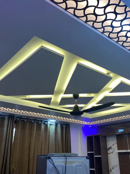 A detailed look at a geometric false ceiling design with integrated LED strip lighting. This adds a dramatic and modern architectural element to the room.