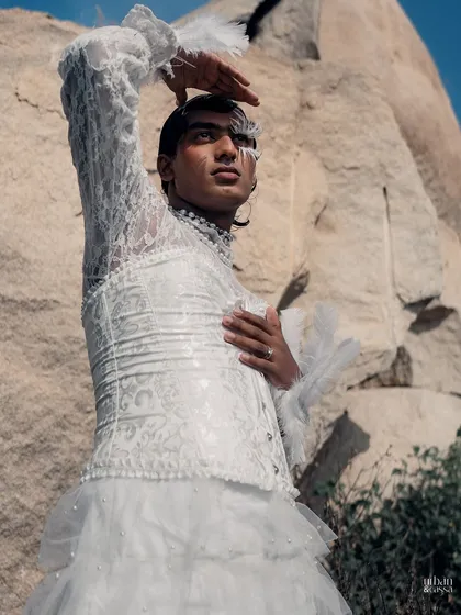 The pose with the hand raised to the sky adds a dramatic, almost theatrical flair to the overall look.