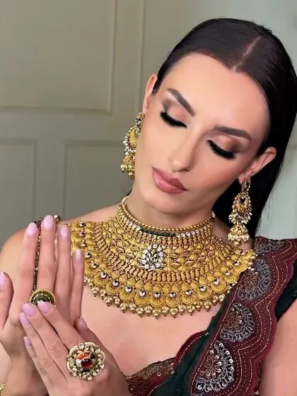 A close-up on the beautiful details of the jewelry and the soft, glamorous makeup. The shimmering eyeshadow and glossy lips create a look of pure luxury.