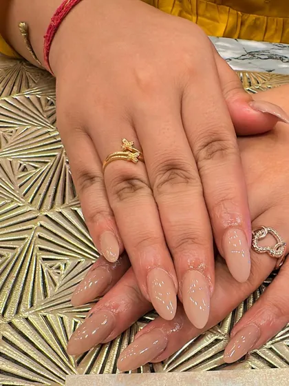 A simple and elegant set of long, stiletto nails in a sheer nude polish. This minimalist look elongates the fingers and is effortlessly chic.