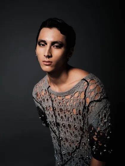 An androgynous, edgy look for a male model in a fashion editorial. I used a dark, smudged graphic eyeliner and styled the hair with a sleek, wet finish to match the avant-garde knitwear.