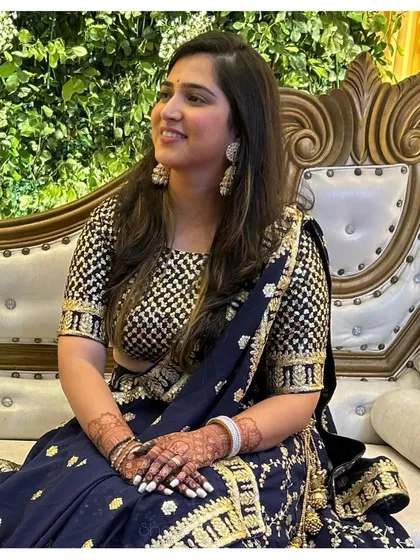 A happy client at her event, her hands adorned with a beautiful dark henna stain that truly shines.