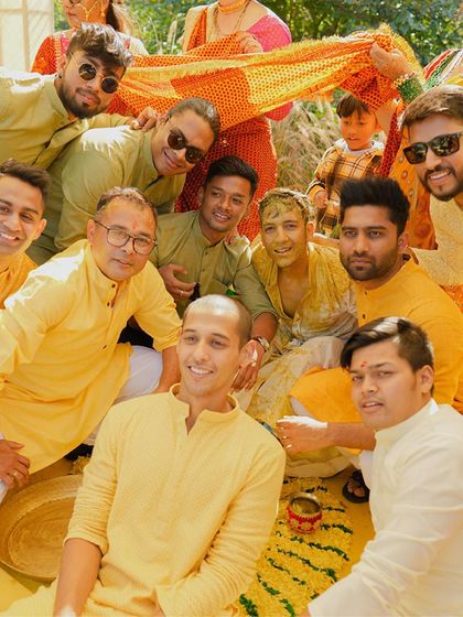 A happy group photo from a Haldi ceremony, with the groom surrounded by his groomsmen in a moment of camaraderie.