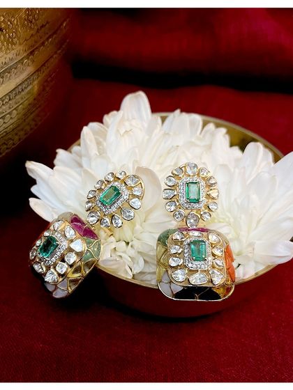 Stunning polki earrings perfect for weddings, parties, or any special occasion. The design features a central emerald surrounded by polki diamonds with colorful meenakari work.