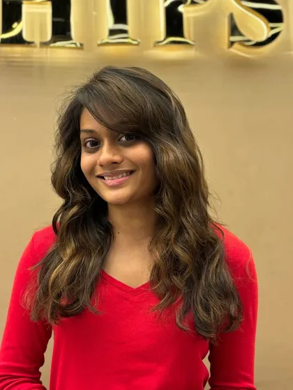 A happy client showing off her new hair color and style. The face-framing bangs and soft waves are a perfect combination.