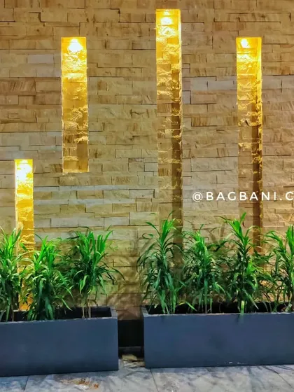 We believe even entrances and covered areas can be green sanctuaries. Here, we used sleek, modern planters and carefully selected indoor plants to complement the stone wall and accent lighting, creating a warm and sophisticated welcome.