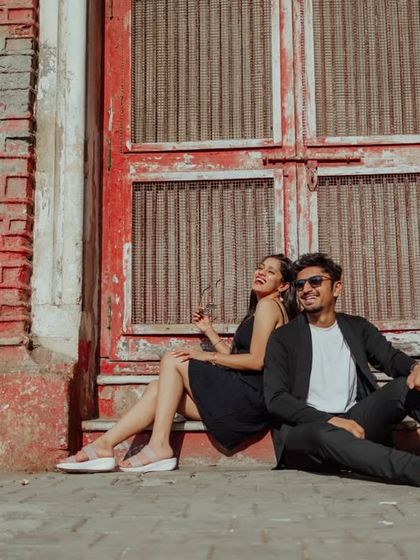 A fun, candid moment of laughter against a rustic red brick wall. These shots showcase your playful side and add a touch of casual, urban cool to your pre-wedding album.