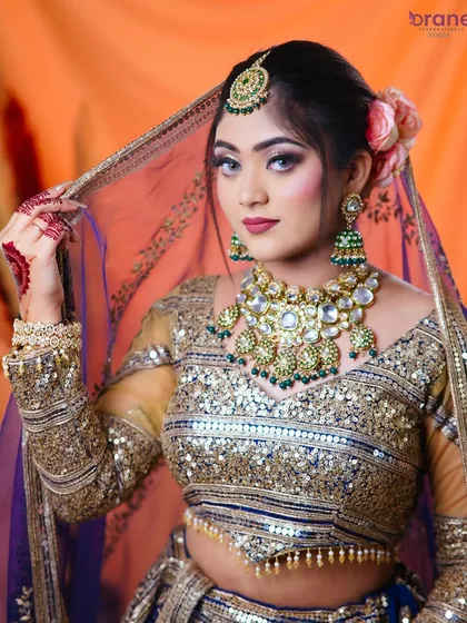 A stunning bridal look featuring a blue and gold lehenga, showcasing our students' ability to work with bold and unconventional colors.