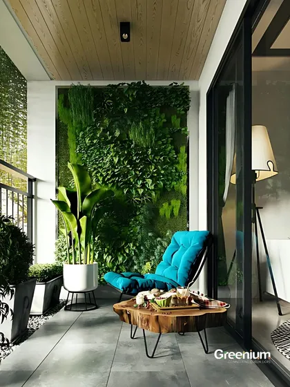 A modern balcony designed for ultimate relaxation. The combination of a comfortable lounge chair, a natural wood table, and a striking green wall creates a chic and serene outdoor space.
