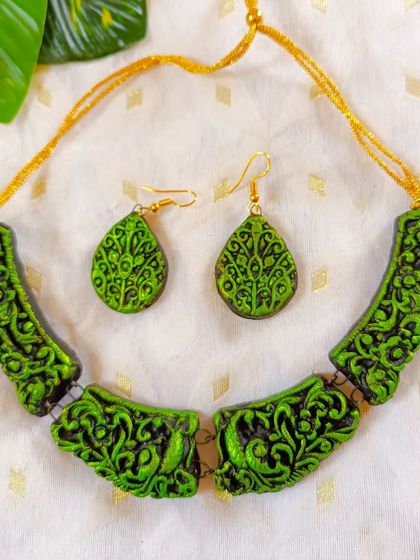 A vibrant green version of the carved 'hansli' necklace. This piece is perfect for making a statement with both ethnic and fusion wear.