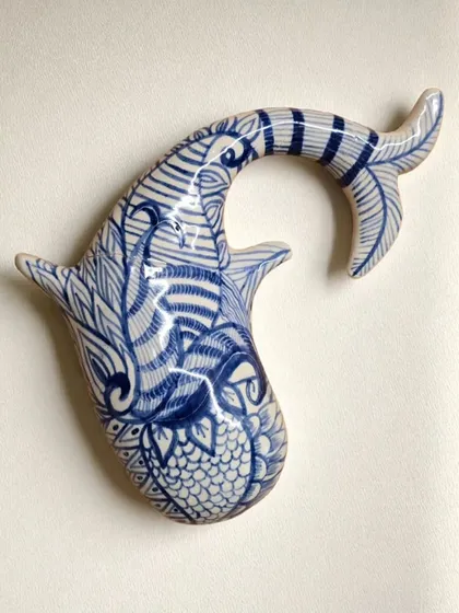 My ceramic wall sculptures are a dialogue between earth and imagination. This hand-painted fish piece is designed to transform your wall into a living story, adding texture, depth, and a touch of serene beauty to your home.