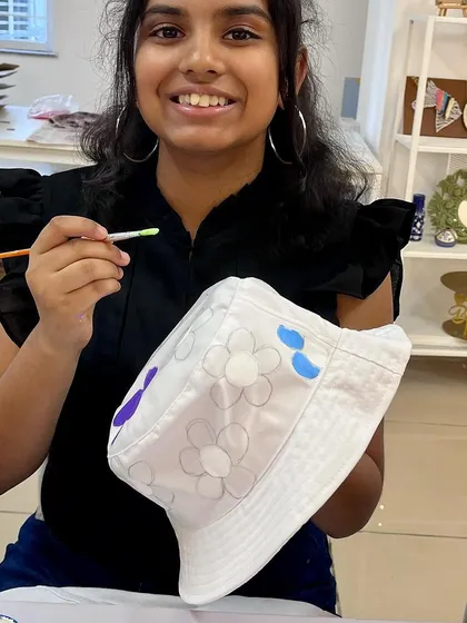 This young lady is adding the finishing touches to her floral-themed bucket hat.