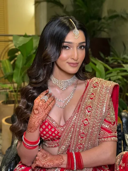 A close-up showcasing the flawless makeup and intricate henna. The soft glam approach ensures her natural beauty is the focus, even with such a bold outfit.