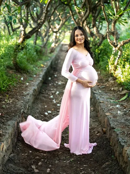 There's something so magical about an outdoor maternity shoot. We found this beautiful tree-lined path in a Mumbai park, and the soft natural light was perfect. This flowy pink gown, which I provide, added just the right touch of fairytale elegance to her solo portrait.