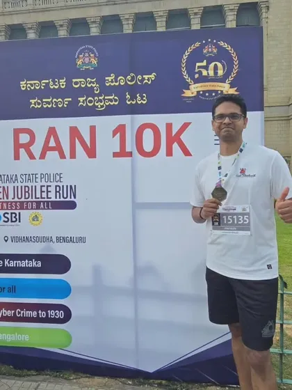 A member of Team Shushanth at the "I Ran 10K" photo booth, celebrating his achievement.