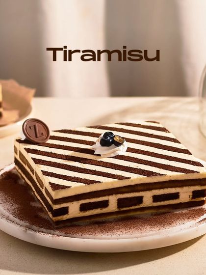 My Tiramisu, presented as a whole cake. The striped pattern created by the cocoa powder gives it a modern, graphic look while honoring the classic Italian dessert.