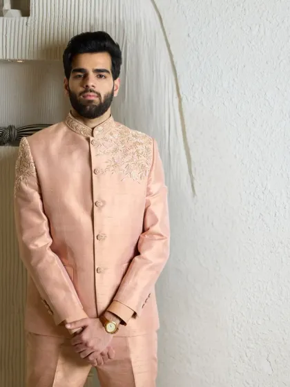 A full-length view of the baby pink bandhgala suit, crafted from raw silk with delicate zari embroidery. A standout piece for any special occasion.