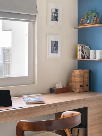 A close-up of the desk area in the 'Living Life in Colours' study, showing the corner shelving and clean lines of the custom workspace.