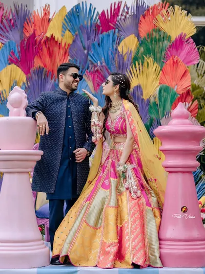 A playful and vibrant shot from a Mehendi ceremony, set against a colorful, modern backdrop. We love capturing the fun and unique themes of pre-wedding festivities.