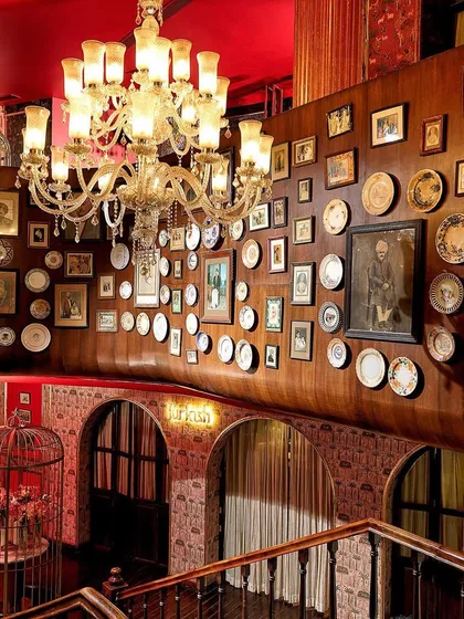 Every detail in my establishment is designed to transport you. This is a view of our grand interiors, where opulent chandeliers and a wall of curated art create a backdrop of timeless, royal luxury for your night.
