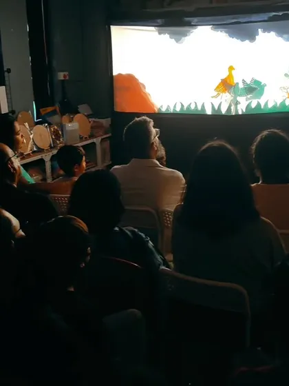 A view from the audience during our intimate shadow puppet show at the studio. The darkened room and glowing screen create a magical atmosphere, drawing everyone completely into the world of the story.
