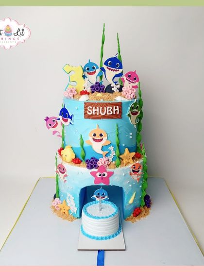 A fin-tastic Baby Shark cake for a first birthday. This tiered creation features the whole shark family in a vibrant underwater scene, complete with a smash cake for the birthday boy.