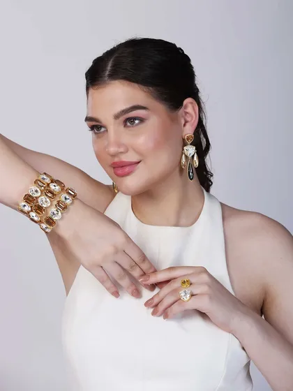 This shot captures the model in a graceful, upward-reaching pose, giving a clear view of the bracelet, ring, and earrings. It’s a versatile image suitable for both web banners and social media.