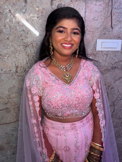 A full-length view of Nireeksha's reception attire. The makeup is balanced to work with the heavily embellished outfit, ensuring the face remains the focal point.