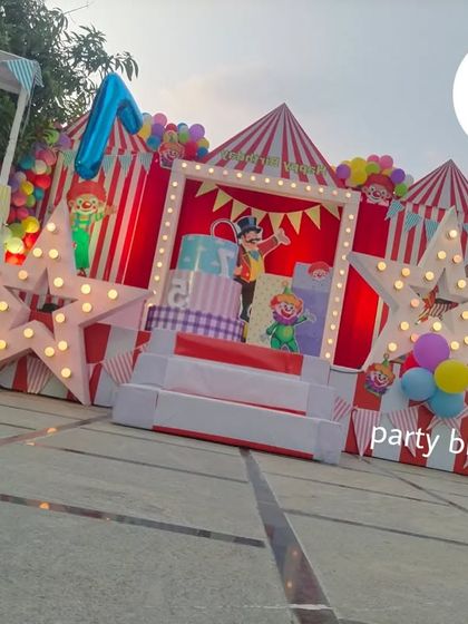 An angled view of the carnival stage, highlighting the multi-layered design with clown props and a custom dessert cart.