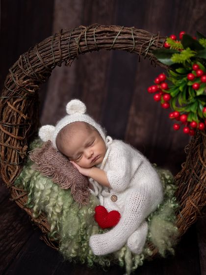A close-up portrait version of the winter wreath shot, perfect for highlighting the baby's adorable features.