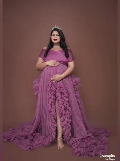 A regal portrait of a mom-to-be wearing a crown and a magnificent purple ruffled gown. Every expecting mother deserves to feel like a queen for a day.
