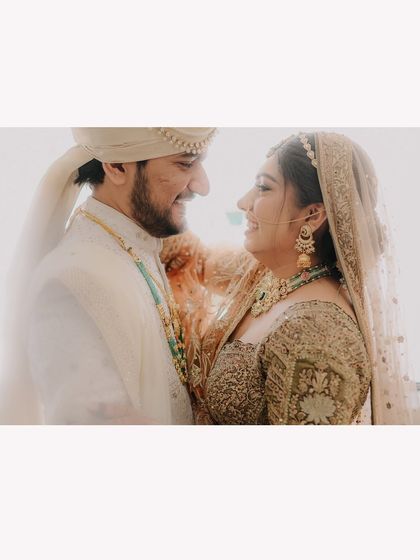 A bright and airy wide shot of the couple sharing a happy, candid moment, creating a light and romantic feel.