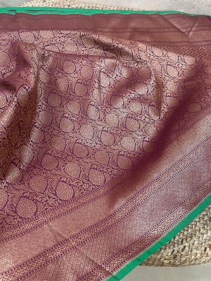 The pallu of this wine-purple Banarasi silk saree features a beautiful paisley jaal weaving, giving it a very traditional and rich look.