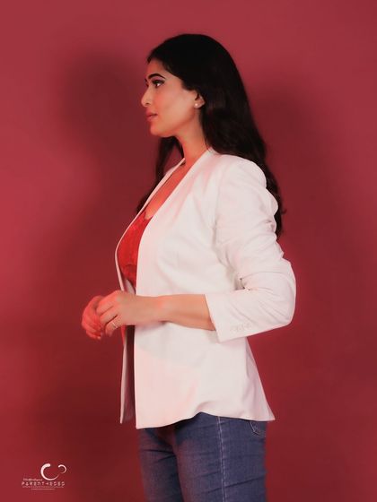 A profile shot that highlights her silhouette against the rich red background. It's a simple yet elegant composition.