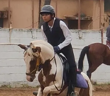 A young rider maintains focus during a group lesson. Learning to ride alongside others builds confidence and a sense of community, even during individual practice.