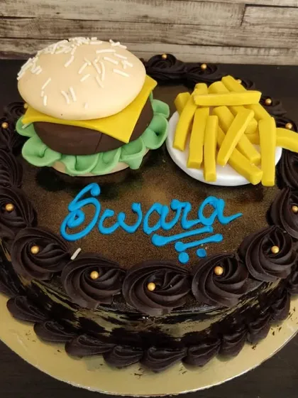 Can't decide between dinner and dessert? Have both! This fun cake is topped with a realistic-looking burger and fries, all made from edible materials.