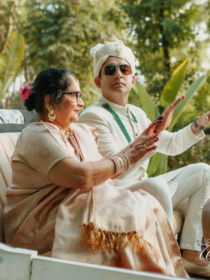 The groom arriving in style in a vintage car with his mother, a classic and elegant choice for a baraat.