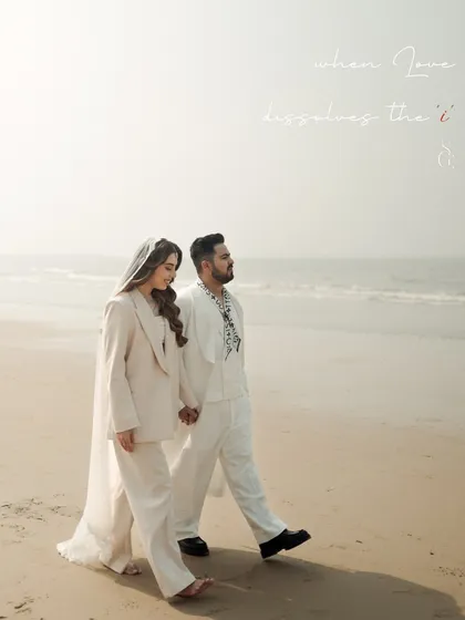 "when love dissolves the 'i'". This poetic phrase perfectly describes the feeling of this beachside portrait. The couple walks as one, their figures blending into the soft, hazy light of the sea.