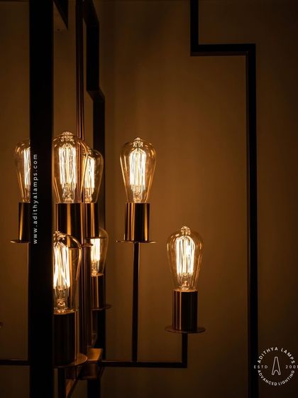Inspired by Art Deco design, this hanging fixture features a strong geometric black frame with exposed vintage-style filament bulbs. The combination of black and warm gold tones provides a sophisticated, retro feel for dining areas or entryways.
